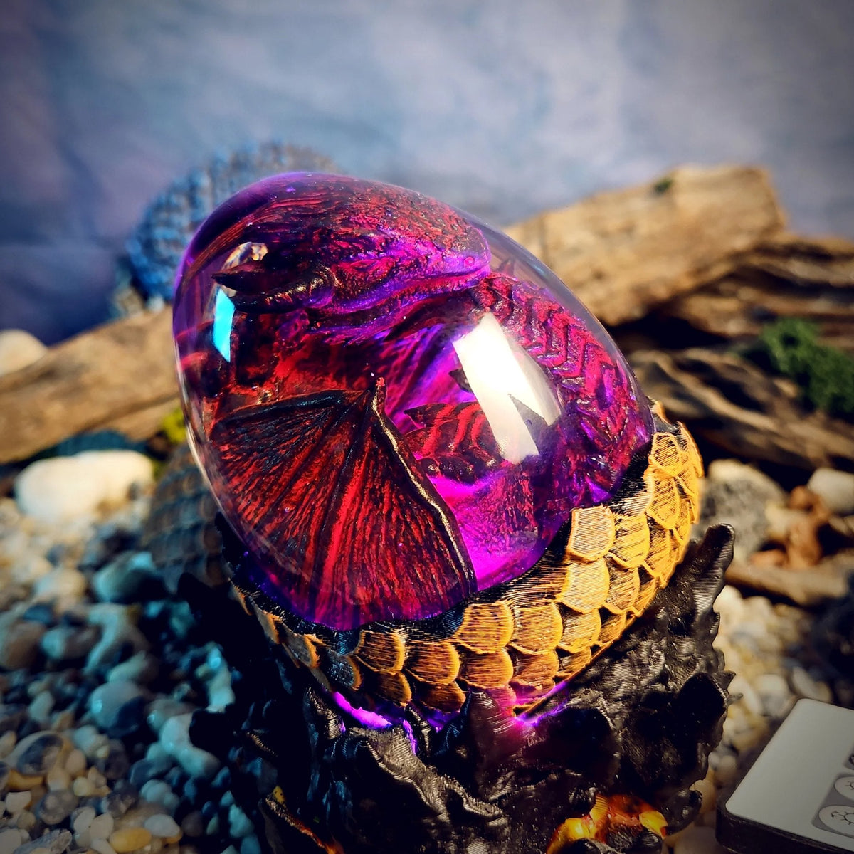 Close-up of the crimson dragon egg glowing magenta on a gold scaled rim