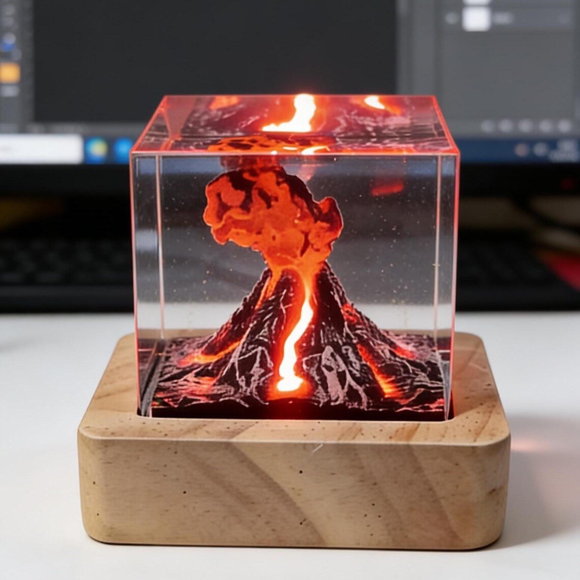 Volcano lava cube lamp glowing in front of a monitor