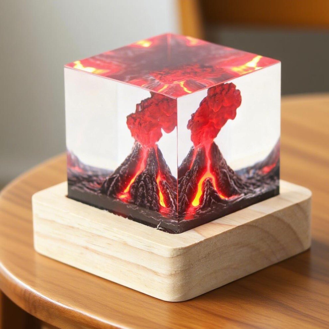 Volcano resin cube on a light wood base, corner view