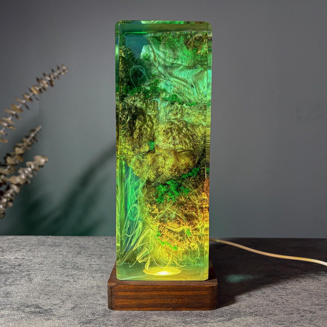 Moss resin lamp glowing green, front view