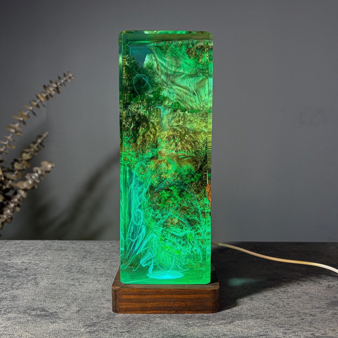 Moss resin lamp glowing green with smoke wisps