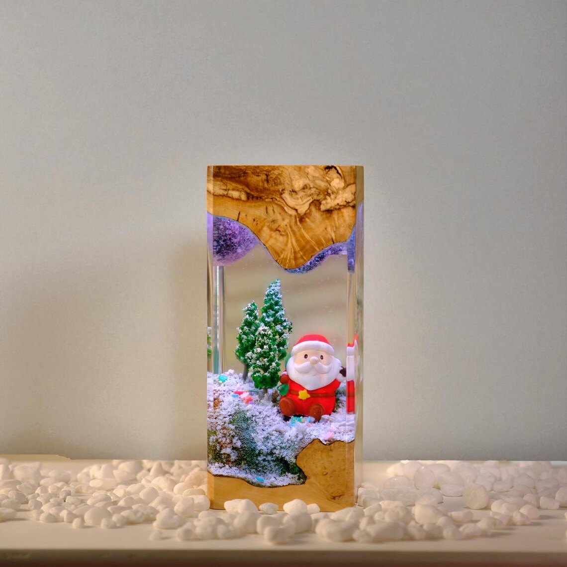 Santa Christmas epoxy lamp, front view on white pebbles