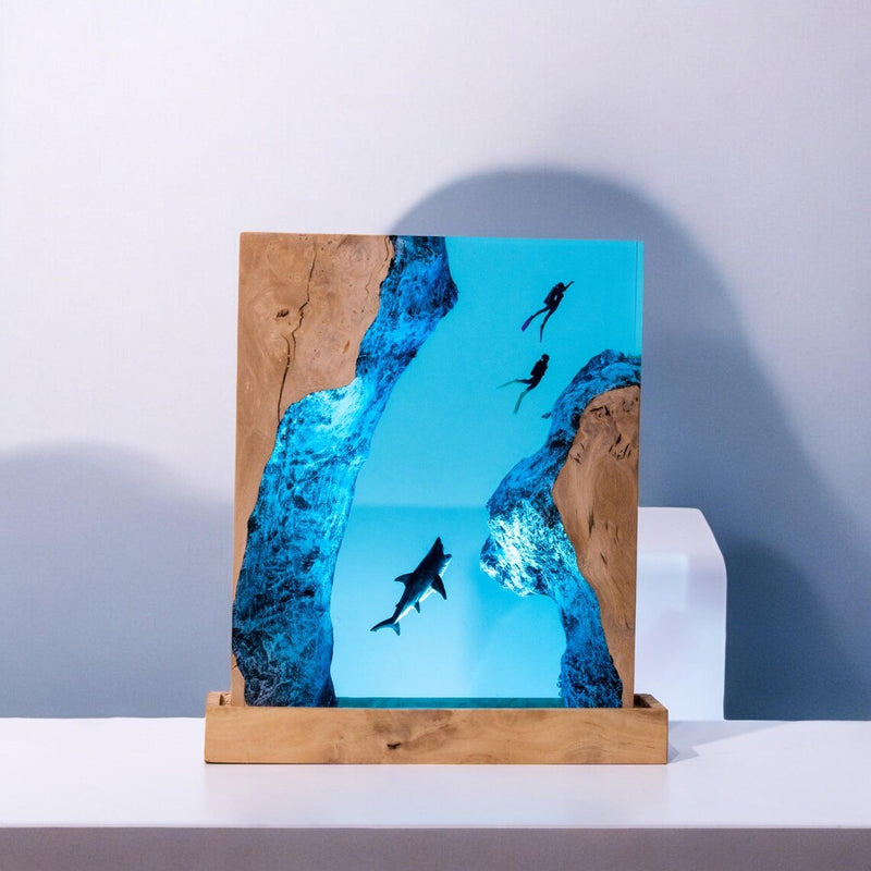 Shark and scuba divers resin lamp with wood edges on a shelf