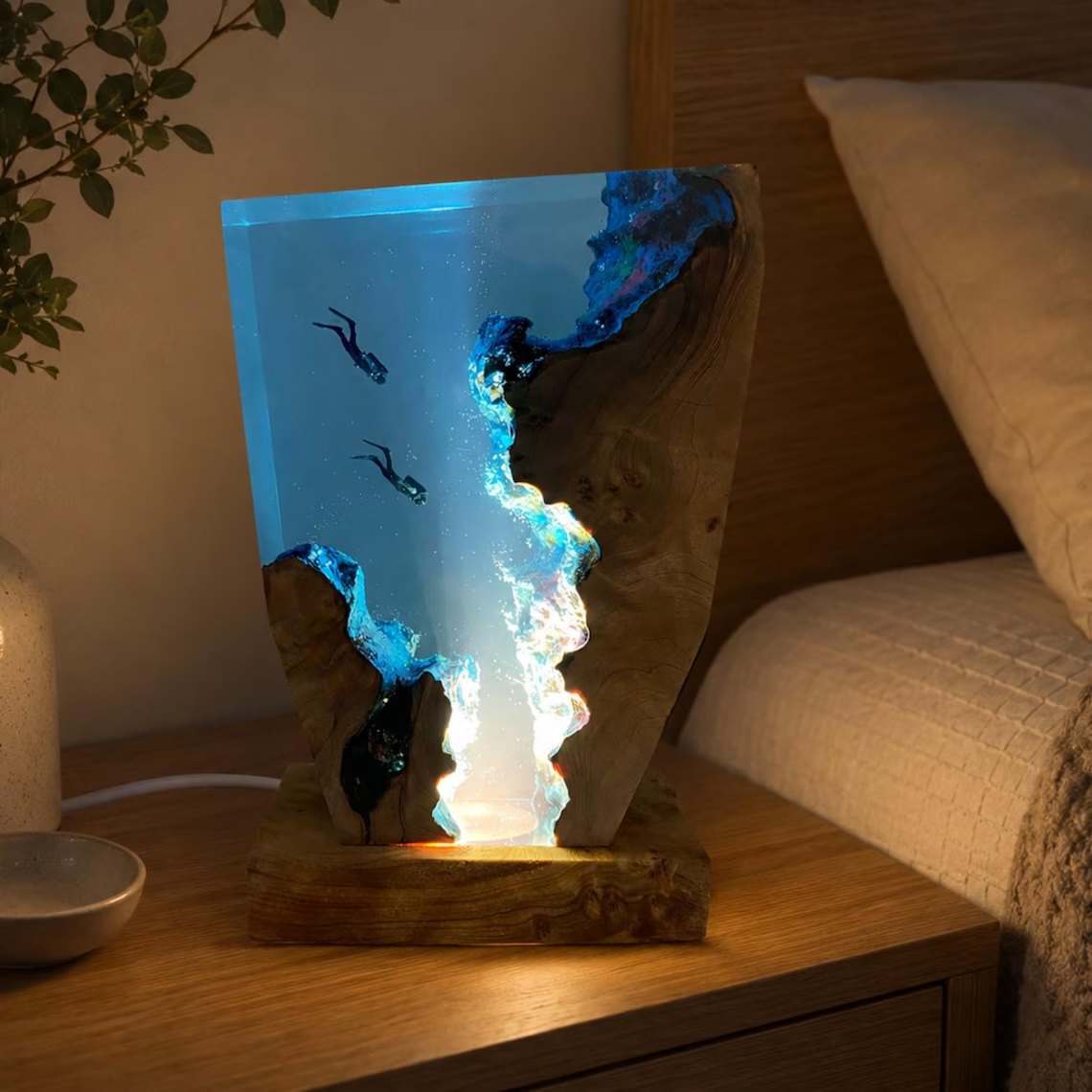Two divers resin lamp glowing on a bedside table