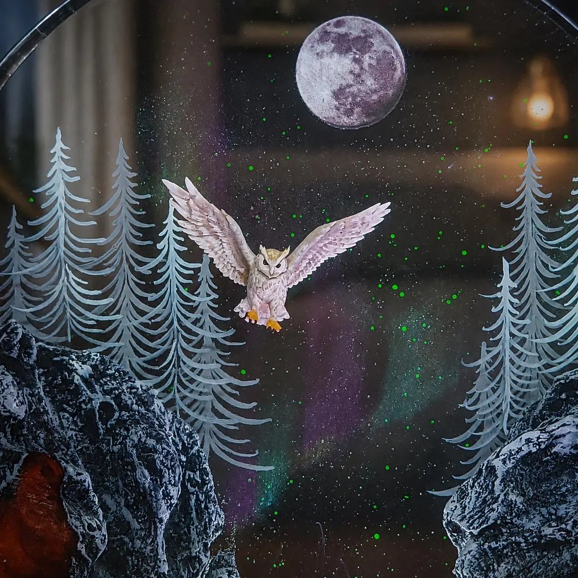 Close view of the white owl in flight between frosted pines